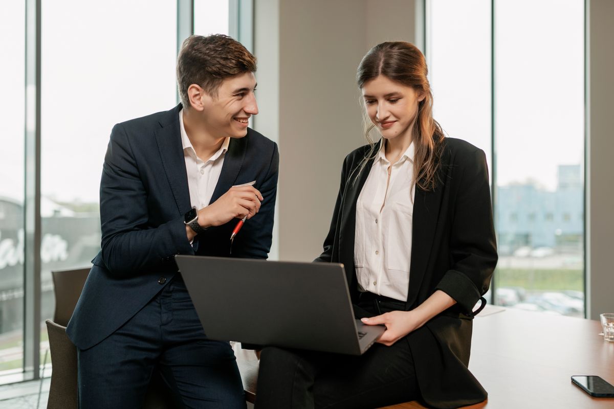 Two colleagues going through work together on a laptop