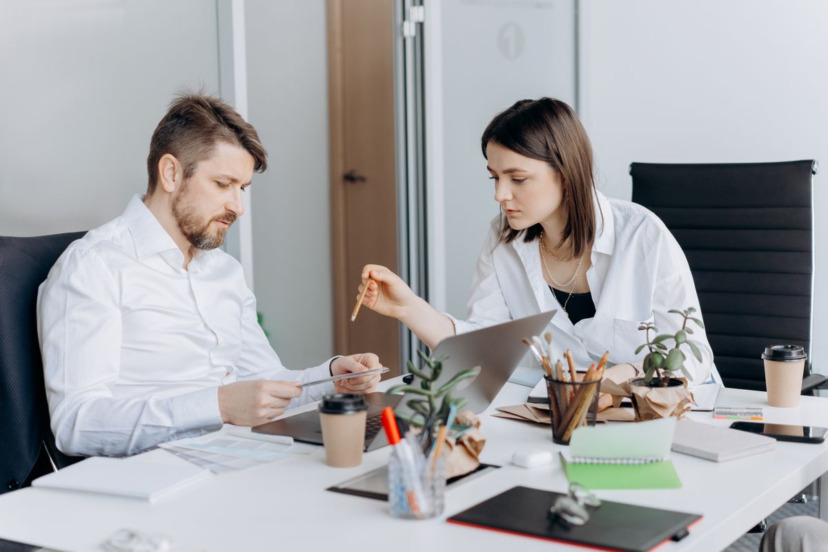 Two colleagues reviewing work together at a desk